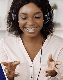 Young lady on phone speaking with someone in a joyful manner.